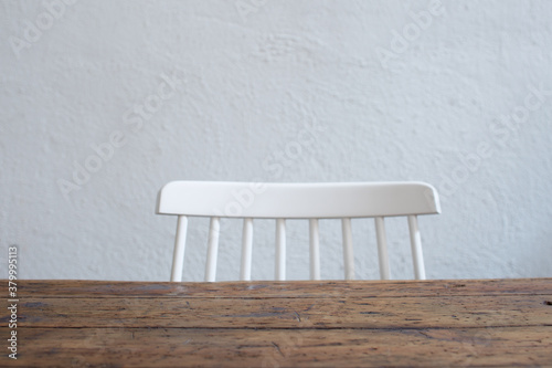 Detail of empty table with white wooden chair