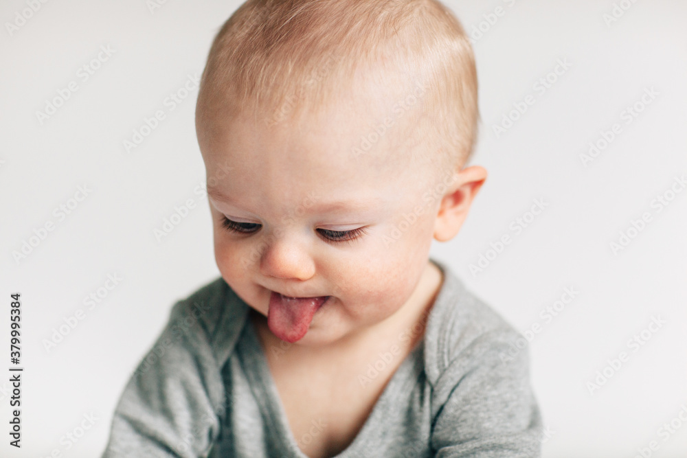 portrait of baby looking down, poking out his tongue portrait of baby looking down, poking out his tongue