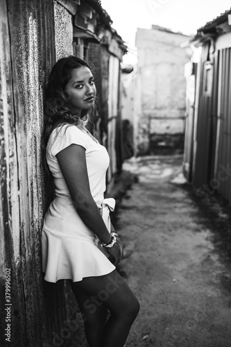 Chica joven con falda en una calle estrecha de un barrio pobre de favela en rio de janeiro brasil con muchos colores en sus casas casseria de ossio san fernando sur de espa  a