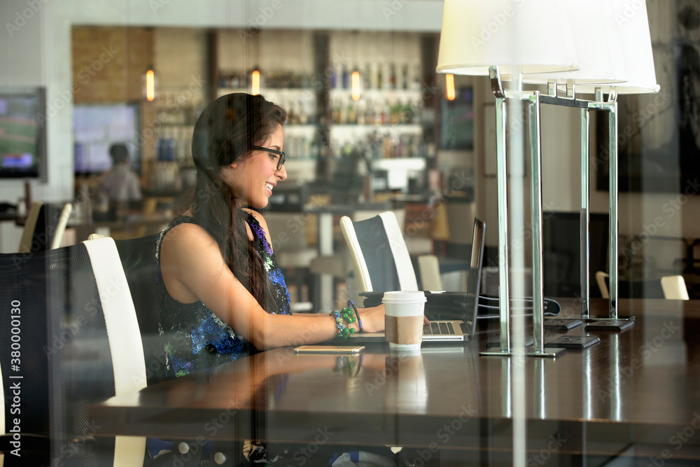 Hispanic woman using laptop in coffee shop Hispanic woman using laptop in coffee shop