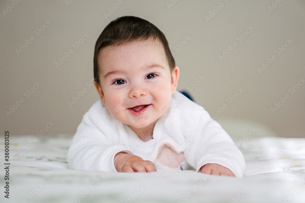 Smiling baby lying down on the bed Smiling baby lying down on the bed