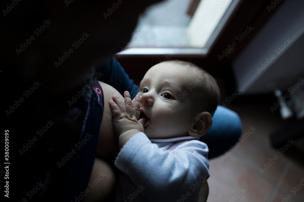 Cute little baby looks at her mother while being breastfed Cute little baby looks at her mother while being breastfed