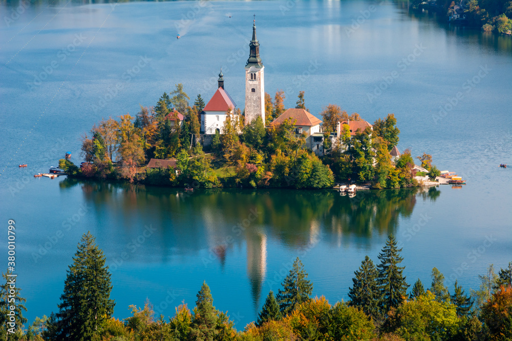 Church on the lake Bled reflected in water.  Lake Bled in fall.