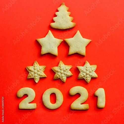 Concept for 2021. Greeting Christmas card made of cookies on a red background. cookies christmas tree shape. Top view