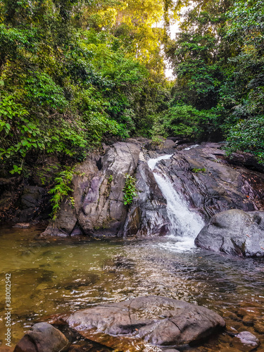 A stormy waterfall among the stones in the dense jungle of Thailand.