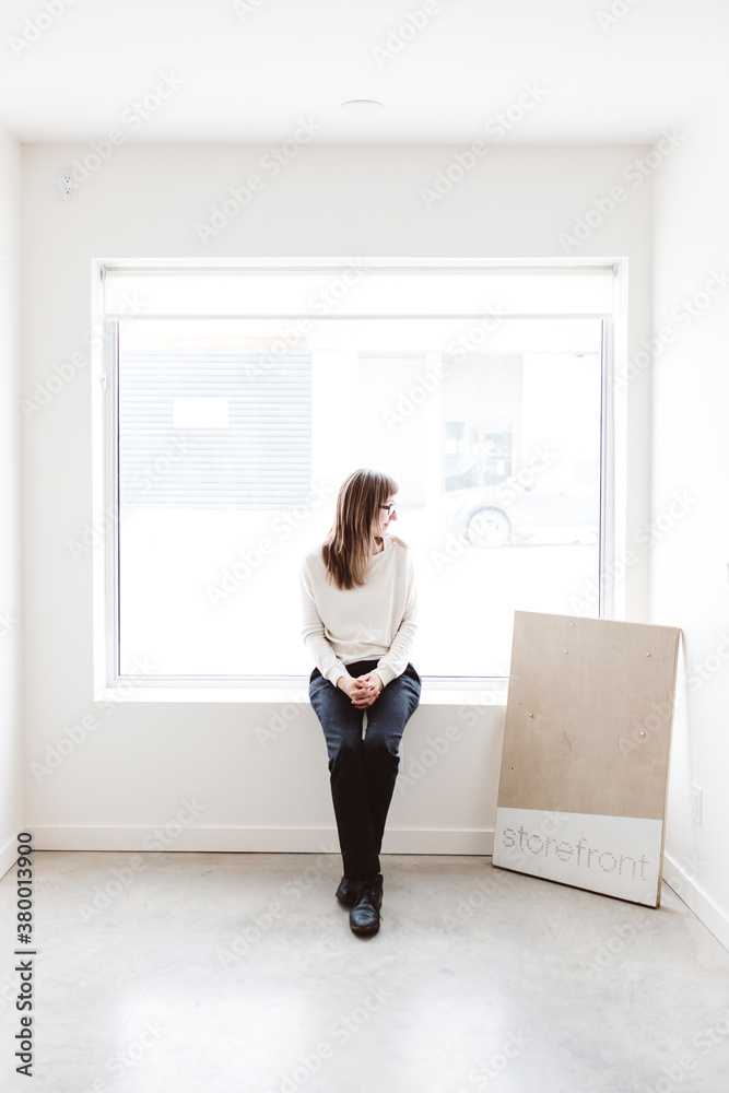 Small business owner sitting in empty storefront Small business owner sitting in empty storefront