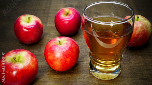 Apple cider vinegar in glass with apples on a wooden background.Selective focus.