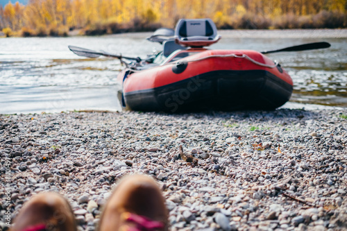 A view of hiking boots and a river raft photo