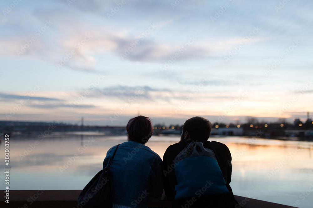 Couple sitting on the river bank Couple sitting on the river bank