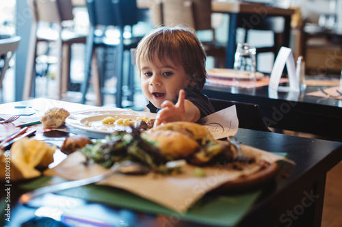 1 year old boy eating a burger photo