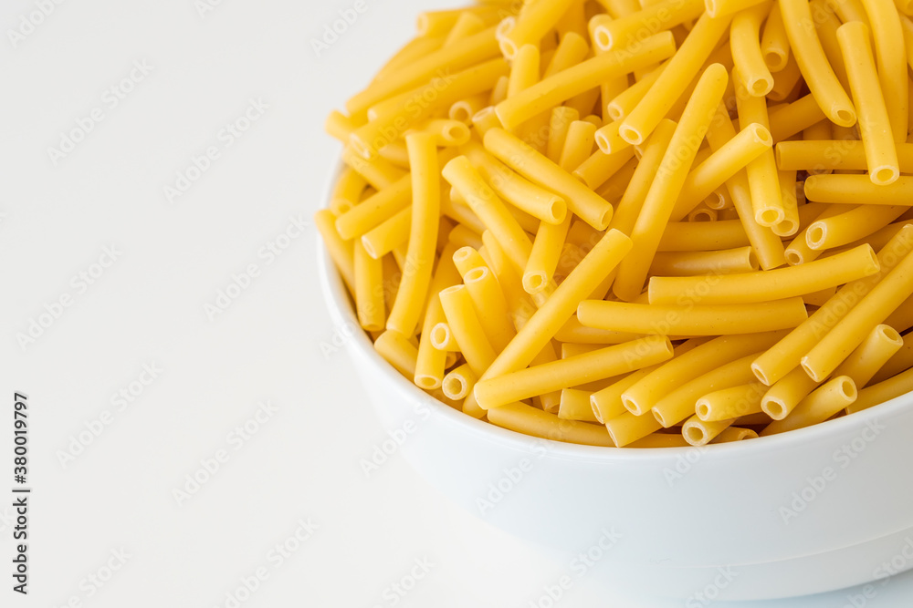 Raw dry uncooked Macaroni pasta spaghetti noodle on white bowl wooden background for basil tomato pesto sauce Homemade Italian food organic whole wheat vegan spaghetti for a healthy meal Raw dry uncooked Macaroni pasta spaghetti noodle on white bowl wooden background for basil tomato pesto sauce Homemade Italian food organic whole wheat vegan spaghetti for a healthy meal