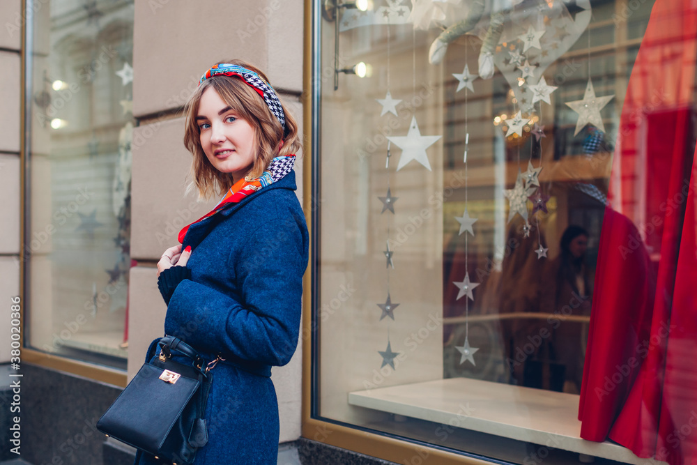 Φωτογραφία Street shot of woman wearing headband scarf coat holding purse outdoors