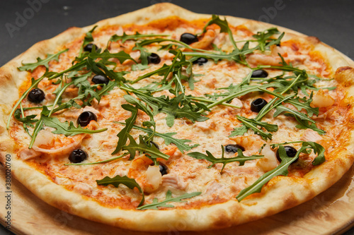 Delicious Italian seafood pizza on dark background
