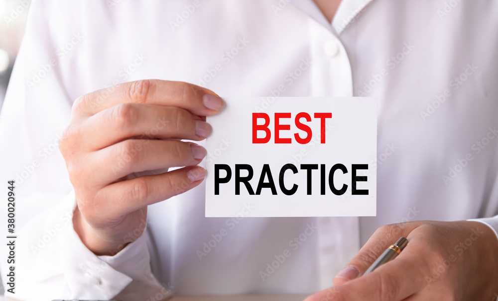 BEST PRACTICE message on the card shown by a businesswoman in a white shirt. Business concept. BEST PRACTICE message on the card shown by a businesswoman in a white shirt. Business concept.