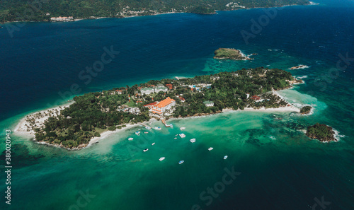 Aerial drone panoramic view of the paradise island with resort hotel, boats, palm trees, white sand beach and blue water of Atlantic Ocean, Cayo Levantado, Samana, Dominican Republic 