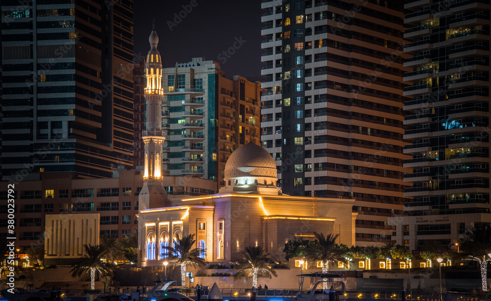 Mosque in between city skyline at night