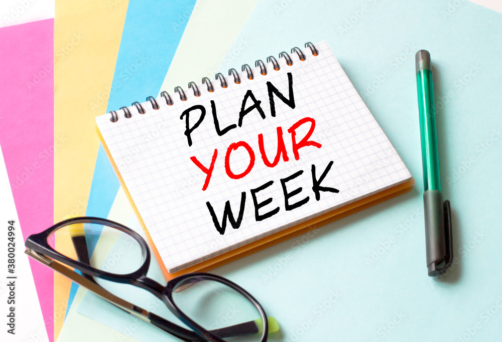 The Notepad with the text Plan Your Week is on colored paper with glasses and a pen The Notepad with the text Plan Your Week is on colored paper with glasses and a pen