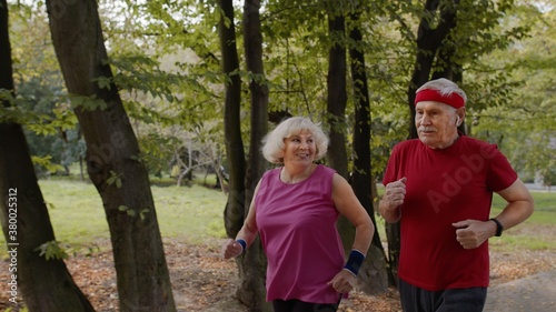 Sporty mature family couple jogging together. Senior husband and wife doing cardio workout exercises