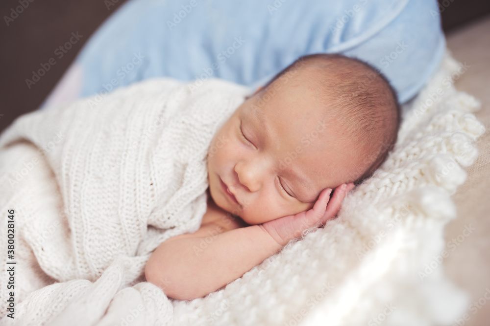 Sweet napping baby wrapped in a knit blanket Sweet napping baby wrapped in a knit blanket
