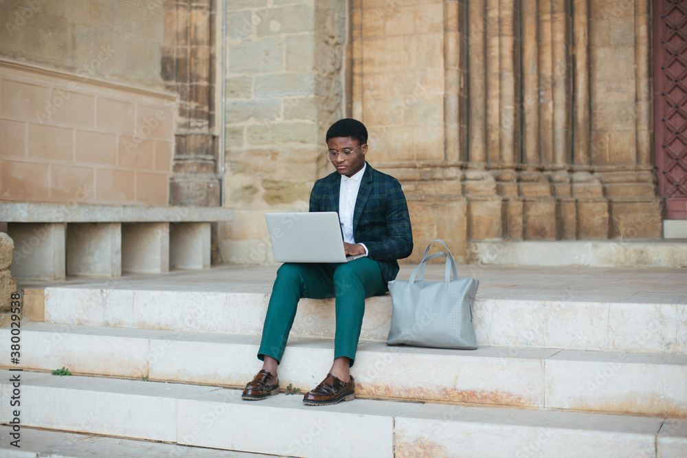 man using laptop on the stairs man using laptop on the stairs