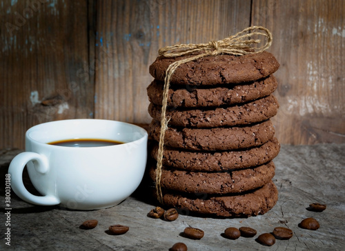Shekoladno oatmeal cookies in a stack on a wooden surface with a cup of coffee