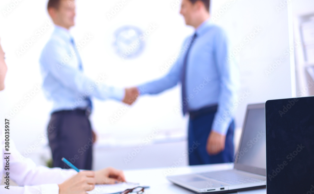 Business people shaking hands, finishing up a meeting, in office