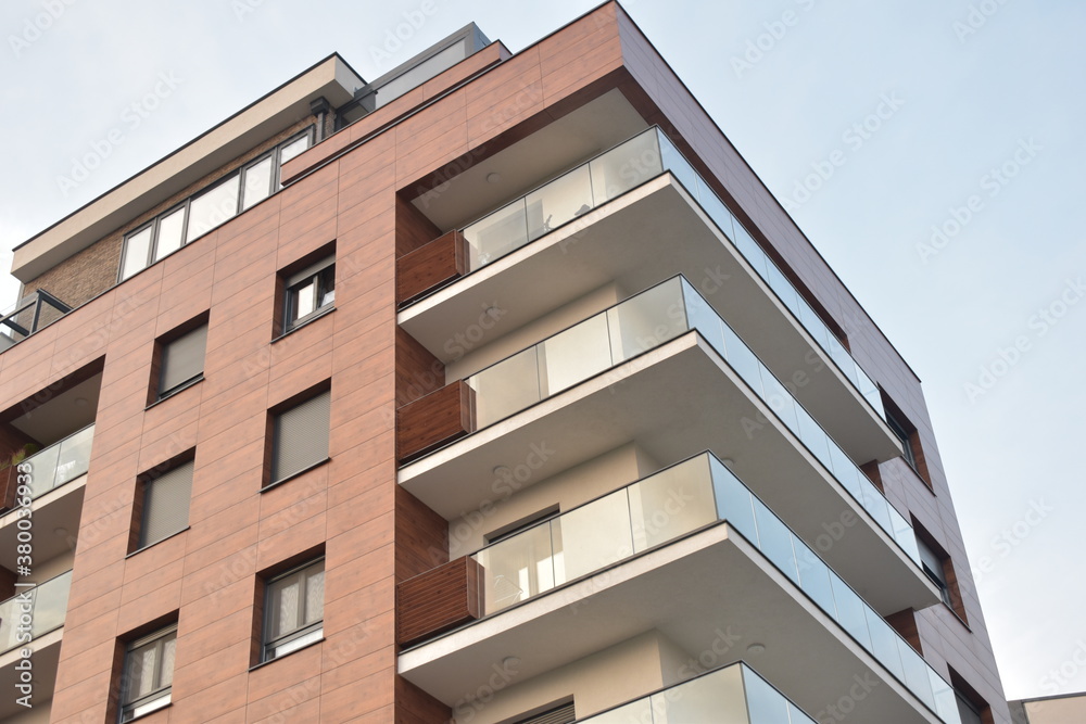 Modern and luxury residential building with glass balcony and brown facade Modern and luxury residential building with glass balcony and brown facade