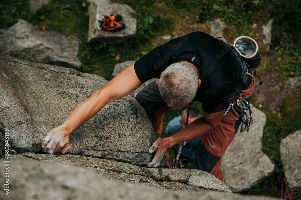 Middle age man free climber climbing in nature Middle age man free climber climbing in nature