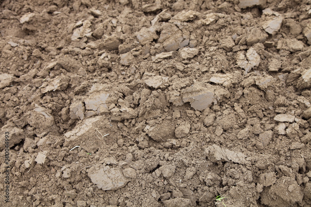 Brown ploughed dry field ground close up fragment — land cultivation, rural background