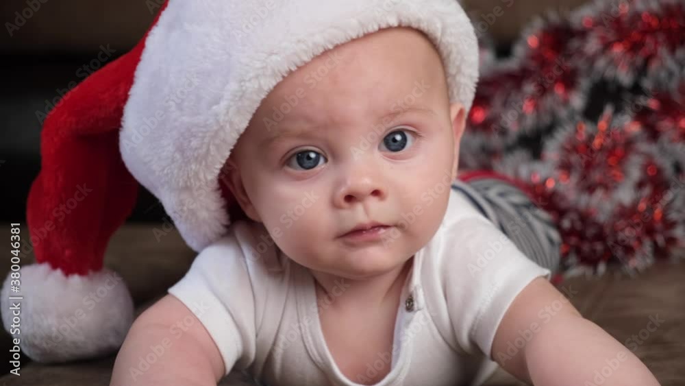 Close up portrait of cute infant baby boy wearing Santa hat. Christmas celebration concept. Close up portrait of cute infant baby boy wearing Santa hat. Christmas celebration concept.