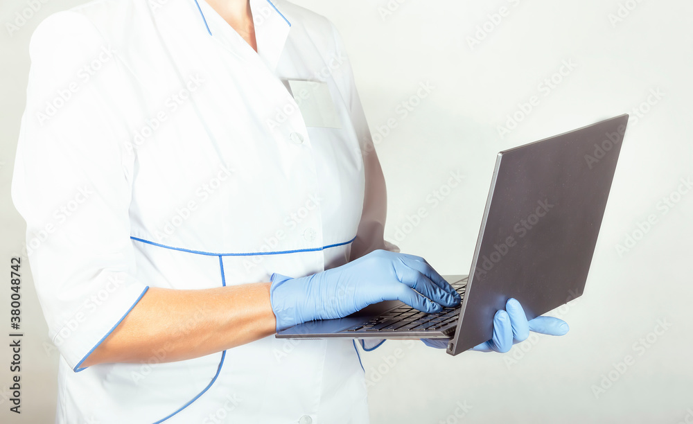 Fototapeta premium Doctor in latex gloves with laptop in hands