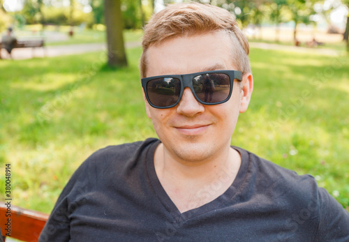 Portrait of a young man on nature background. Emotion facial expression.