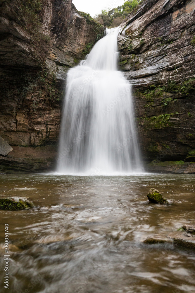 Obraz premium Beautiful place with a waterfall that falls from the rocks of the mountain with the smooth water in long exposure. Tourism in Spain, Catalonia, Barcelona, Osona, Cantonigros, La Foradada.
