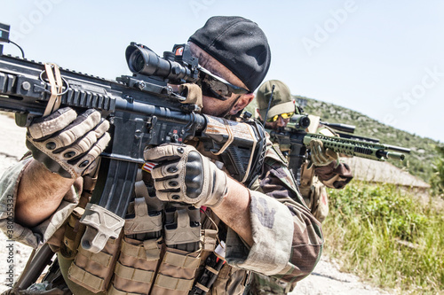 Commando team fighters, special operations or anti terrorist squad snipers, marksman aiming guns through optical signs, hiding in ambush, observing territory. Service rifle barrel closeup shoot