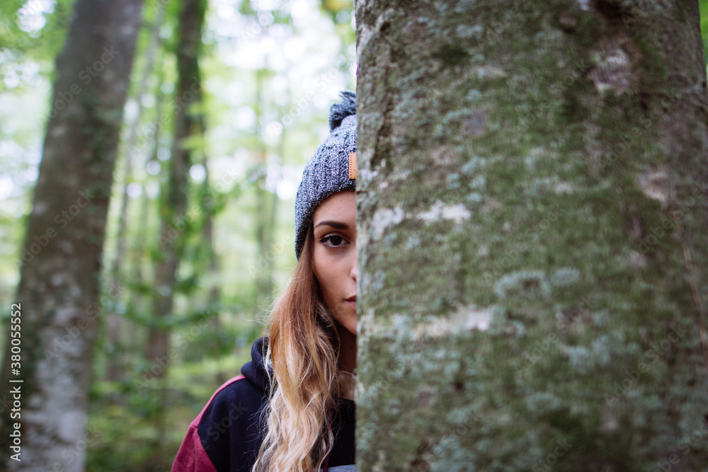 Portrait of young woman behind a tree Portrait of young woman behind a tree