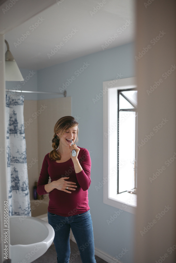 Content pregnant woman at home brushing her teeth Content pregnant woman at home brushing her teeth