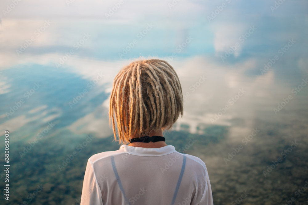 Woman from back infront of sea reflection Woman from back infront of sea reflection