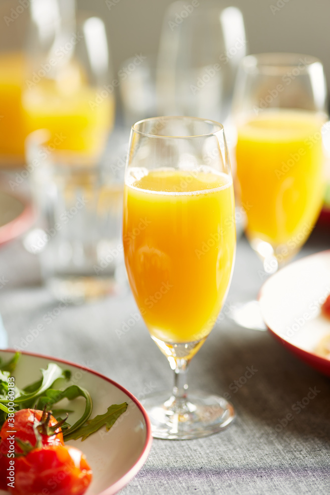 Mimosa cocktail with plate of arugula and roasted tomatoes. Mimosa cocktail with plate of arugula and roasted tomatoes.