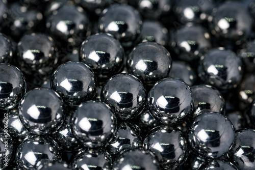 Metal balls with shiny reflections. The balls are arranged next to each other, the structure is made of many elements. Slingshot bullets, ball bearings.