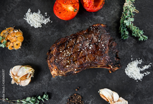 beef steak on the bone with tomato garlic and herbs photo