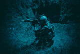 Army soldier, special forces infantryman in combat uniform and helmet, armed assault rifle, sneaking in darkness, crawling in trench at night. Commando fighter, combatant hiding from enemy fire