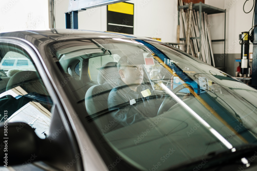 Asian car mechanic working in his auto repair shop Asian car mechanic working in his auto repair shop