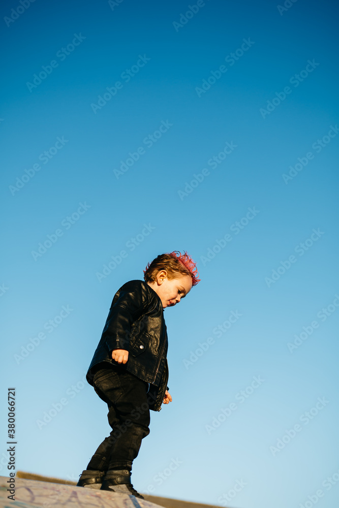Punk boy looking down over blue sky. Punk boy looking down over blue sky.