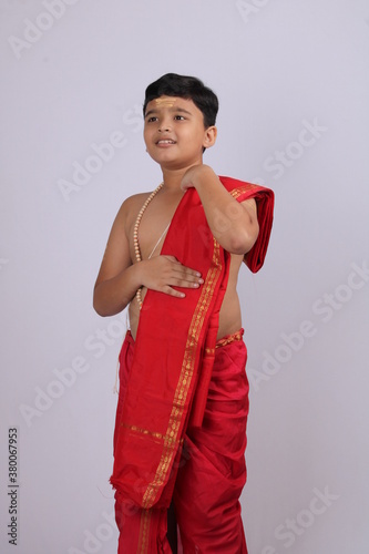 cute Indian boy in ethnic wear sovla and uparna - dhoti and stole. holding his stole. photo