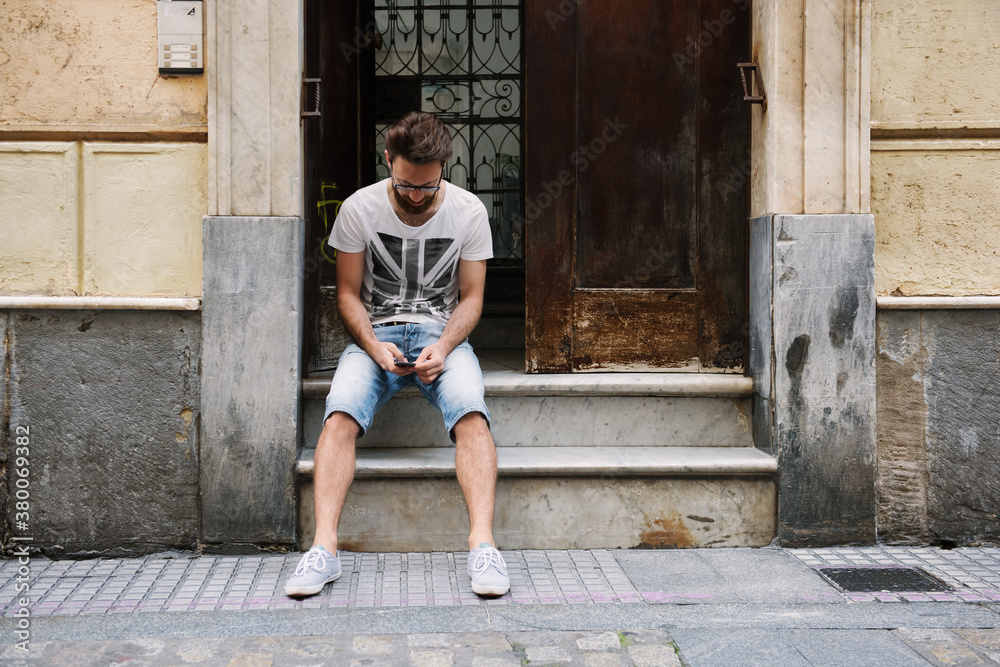 Man browsing phone on stairs