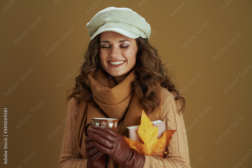 smiling stylish woman in sweater isolated on beige