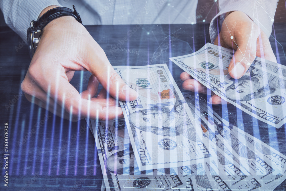Multi exposure of financial graph drawing hologram and USA dollars bills and man hands. Analysis concept. Multi exposure of financial graph drawing hologram and USA dollars bills and man hands. Analysis concept.