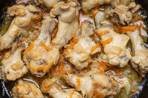 prepared chicken wings at frying pan on a wooden desk. domestic cooking