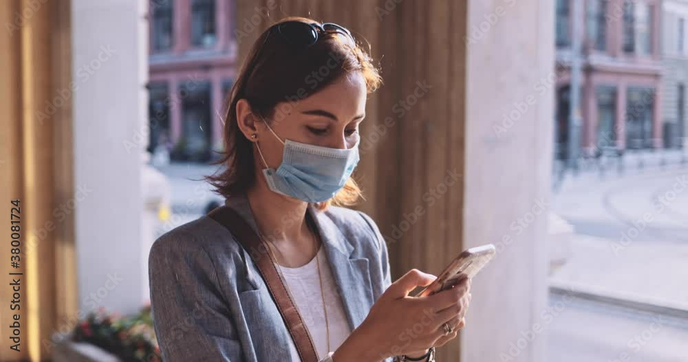 Woman Wearing A Protective Mask Walking In The City, Using Smartphone. SLOW MOTION, Gimbal Stabilizer. Young Female in face mask against air pollution and coronavirus Covid-19. Urban Morning. Woman Wearing A Protective Mask Walking In The City, Using Smartphone. SLOW MOTION, Gimbal Stabilizer. Young Female in face mask against air pollution and coronavirus Covid-19. Urban Morning.
