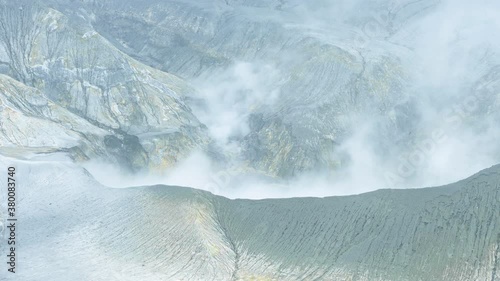 View from above, stunning aerial view of the Tangkuban Perahu volcano with clouds of gases raising from the crater. Tangkuban Perahu is an active volcano, situated 30 km north of the city of Bandung photo